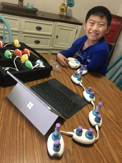 Young boy at a table with APH's Code Jumper