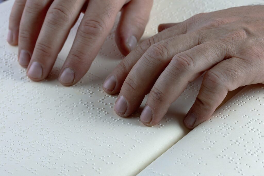 Fingers reading a braille page. 