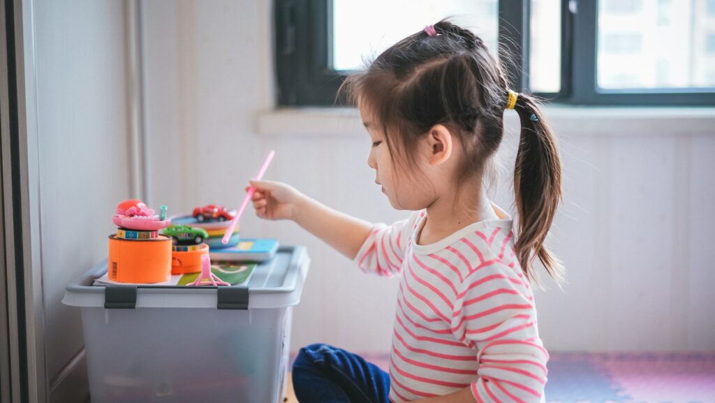 A young girl with a straw doing crafts on a table