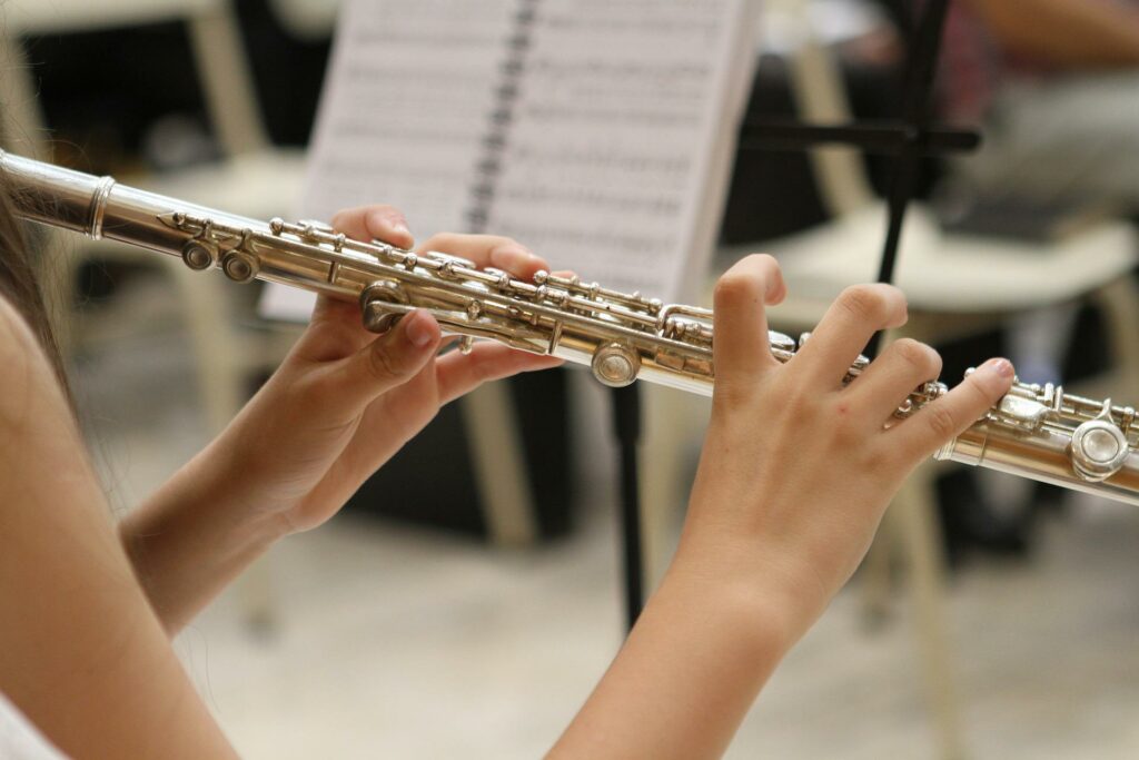 Close-up of young person playing the flute