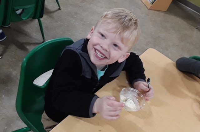 Fair-Skinned boy sitting at a table and smiling