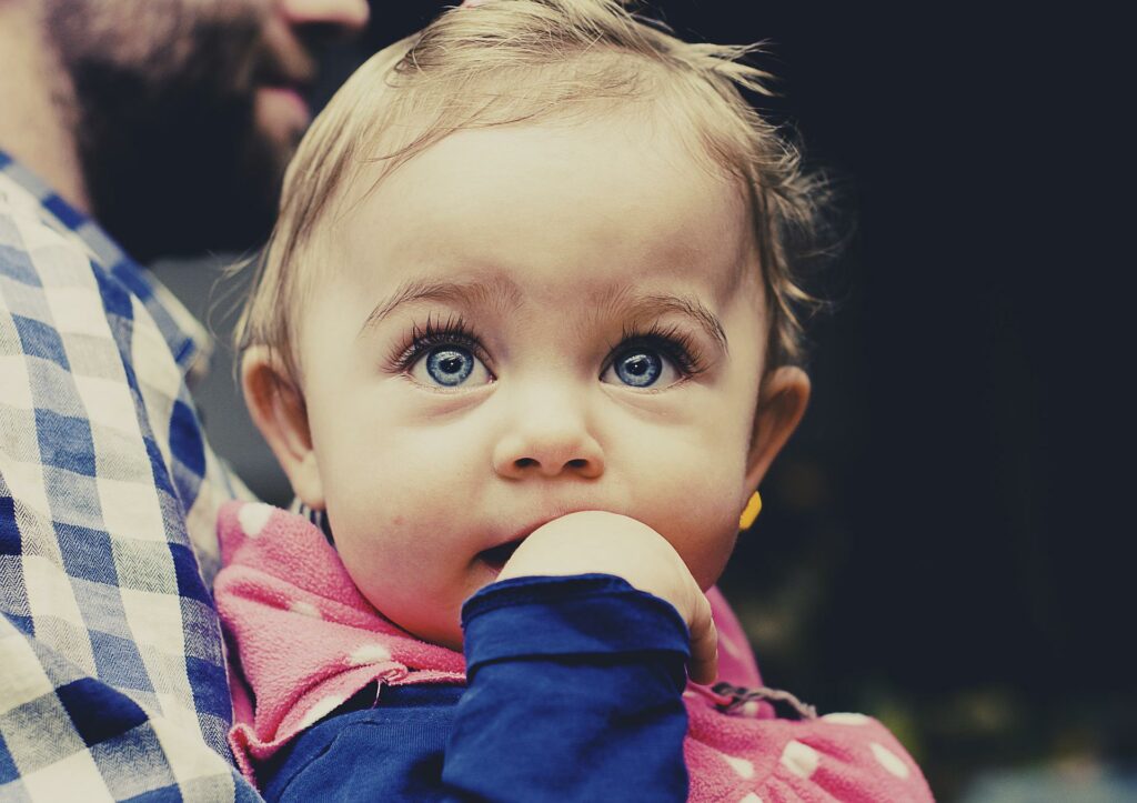 Dad holding infant with large, blue eyes