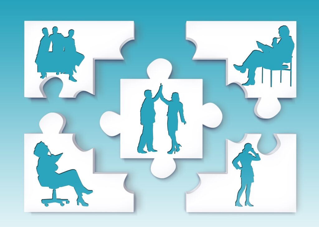 Puzzle pieces with silhouettes of individuals in business attire