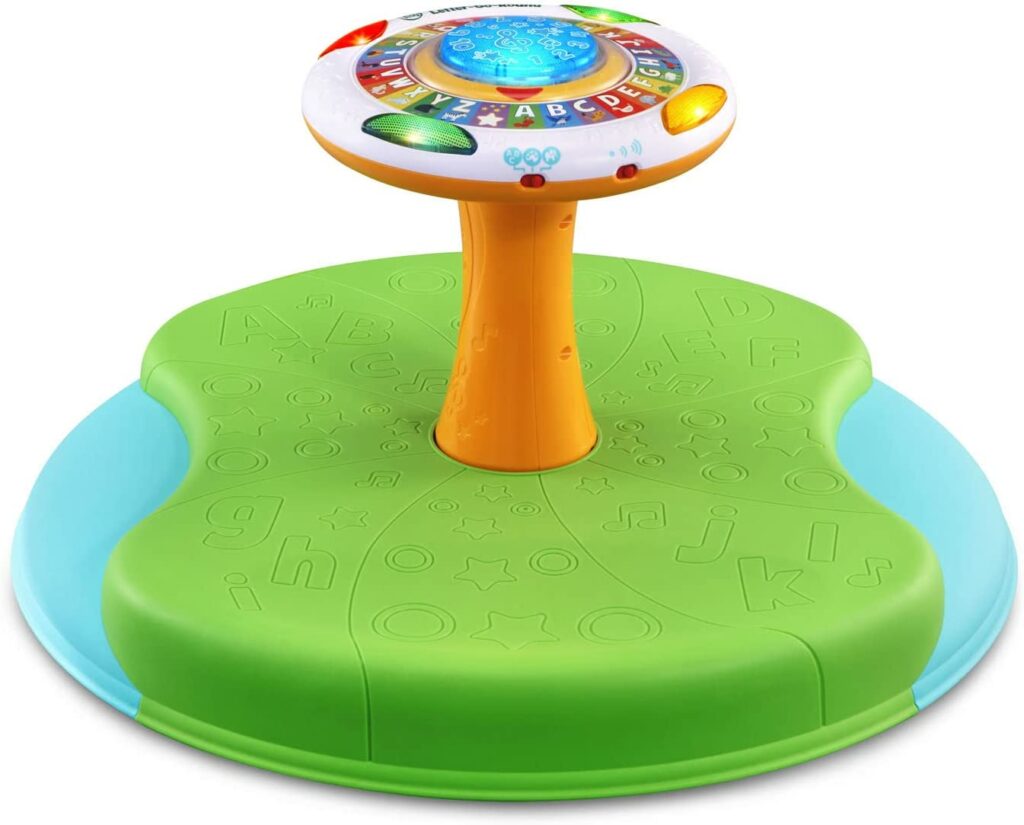 A green and blue sit and spin with light up alphabet and colored buttons on the top. 