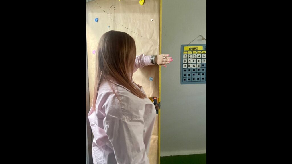 Woman using upper hand technique to find the door. Mujer usando la técnica de protección alta para encontrar la puerta.