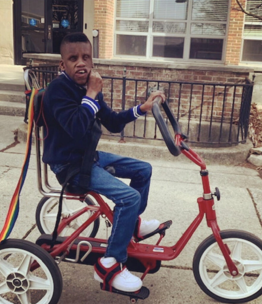 Child riding an adaptive tricycle